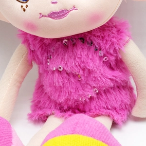 Close-up of pink plush doll dress with sequins and detailed facial embroidery art