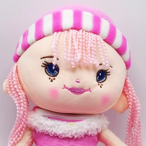 Close-up of cute plush doll featuring pink knitted hat and detailed facial embroidery