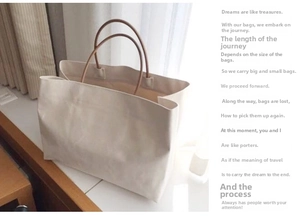 Detailed view of a minimalist large capacity white canvas tote bag with brown leather straps
