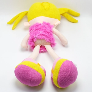 Detail of plush doll showing yellow braided hair and pink faux fur dress with silver sequins