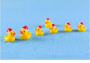 Macro view of mini Christmas yellow resin ducks with festive hats for micro landscape