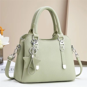 Chic pale green lychee leather handbag with silver hardware and a star charm