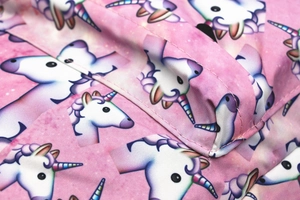 Dettaglio del tessuto con stampa a unicorno e cuciture di alta qualità su zaino rosa
