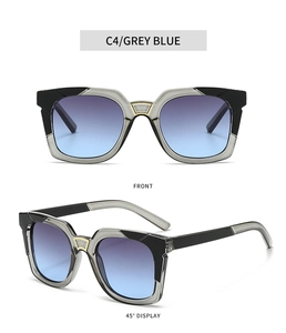 Detail view of square sunglasses with grey blue gradient lenses and golden metal bridge