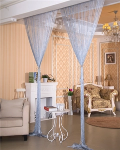 Detail of light blue glitter string curtains tied in a luxuriously decorated living room