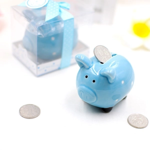 Blue ceramic piggy bank with white polka dots and coins on a desk in a macro detail shot