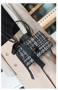 Detail of tweed handbag featuring a large black satin bow and elegant metal buckle
