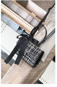 Chic tweed crossbody bag with a large silk bow and metallic clasp shown on model