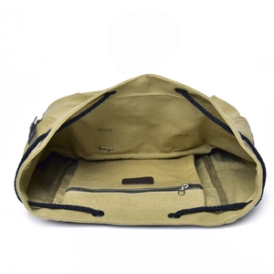 Internal structure of khaki canvas backpack showing main compartment and zipper pocket