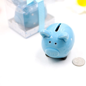 Blue ceramic piggy bank with white dots next to its gift box with blue ribbon
