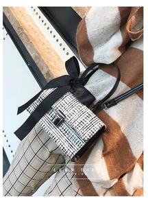 Detail of tweed crossbody bag with silver clasp and decorative silk bow handle