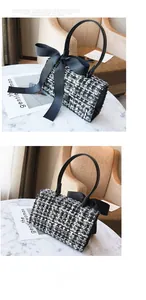 Detail of tweed checkered handbag with black silk bow decoration and leather handle