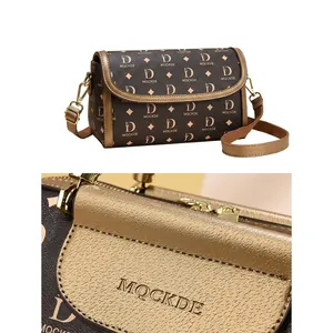 Close-up of golden embossed MOCKDE logo on vintage monogram printed leather handbag