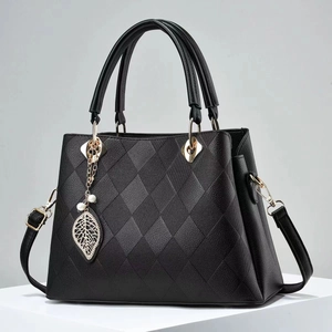 Detail of black Saffiano handbag with diamond quilting and pearl leaf pendant