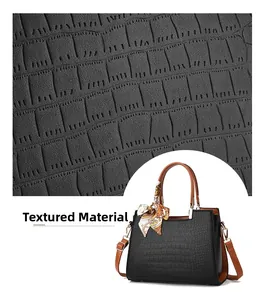 Detail of black faux crocodile texture and stylish printed scarf on the handle