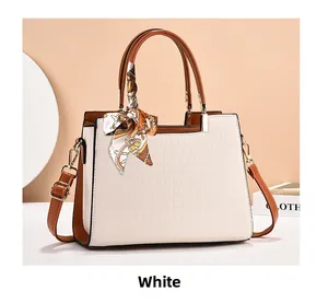 Detail view of white crocodile pattern tote bag featuring a decorative printed silk scarf