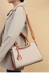 Detail of cream and orange faux-crocodile handbag showing textured surface and hardware