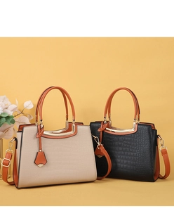 Detail of elegant crocodile texture handbags in beige and black with golden hardware