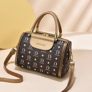 Vintage brown crossbody handbag with gold D-pattern and metal handle on beige background