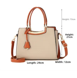 Detail view of beige crocodile embossed leather bag with orange trim and dimensions