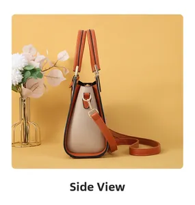 Side view of two-tone orange and beige handbag with gold hardware on yellow background
