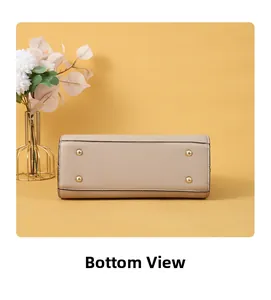 Detail view of the handbag bottom featuring four gold metal protective feet on beige leather