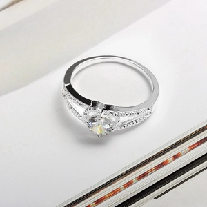 Detailed macro view of silver heart ring with round cubic zirconia and hollow filigree