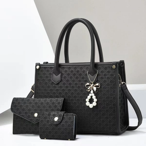 Close-up of three-piece black woven tote bag set with elegant pearl and bow charms