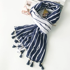 Close-up of blue and white striped cotton linen scarf with gray tassel and wooden bead detail
