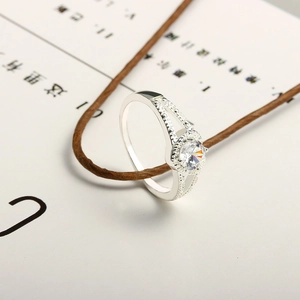 Elegant silver ring with a round center stone and diamond-encrusted split shank design