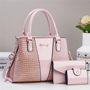 Detailed view of pink three-piece handbag set featuring crocodile pattern texture