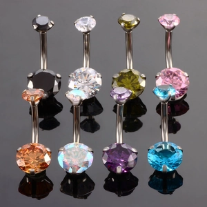 Macro shot of 8 colors of cubic zirconia belly rings on a black reflective surface