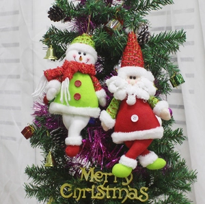 Detail of plush Santa and Snowman ornaments with sequins hanging on a Christmas tree