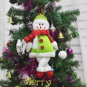 Cute snowman plush ornament with green hat and red scarf hanging on a Christmas tree
