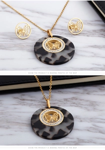 Detail of gold butterfly necklace and earrings set with shell pattern and rhinestones