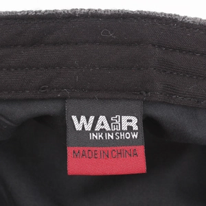 Détail intérieur du bonnet en maille chaude montrant la couture et l'étiquette de marque
