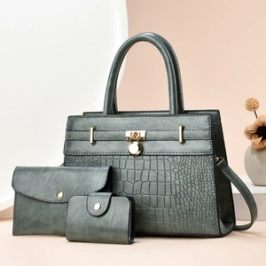 Close-up of a 3-piece dark green handbag set featuring crocodile texture and gold hardware