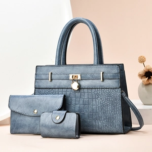 Three-piece women's handbag set in misty blue with embossed crocodile pattern and gold hardware