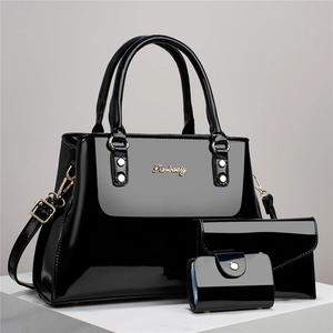 Detailed macro view of 3-piece set in glossy black patent leather with gold hardware
