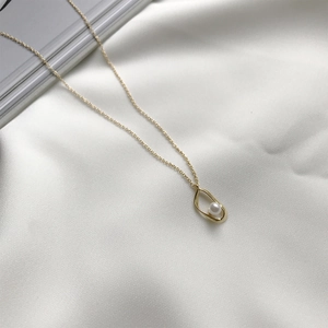 Detailed view of 925 silver golden pearl necklace with droplet pendant on silk fabric