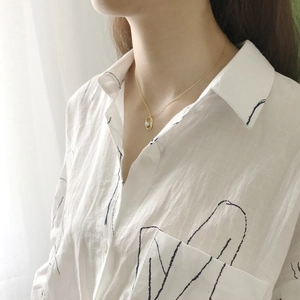 Detail of 925 sterling silver gold necklace with irregular frame and pearl on model