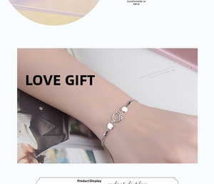 Detail showing dual-strand silver cat charm bracelet worn on a female wrist