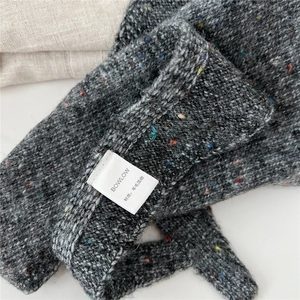 Détail de la texture en laine mélangée avec des taches colorées et étiquette