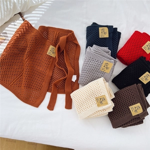 Schicker Strickrock mit Hohlmuster und Bindeband in verschiedenen Farben auf hellem Grund
