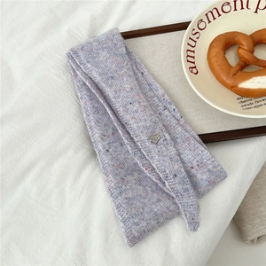 Gros plan sur écharpe en laine tricotée lilas avec mouchetures et breloque coeur