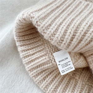 Détail du bonnet en laine avec texture côtelée épaisse et composition de la matière