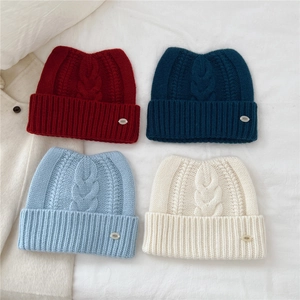 Mise à plat de quatre bonnets en laine avec oreilles de chat en diverses couleurs