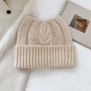 Gros plan sur le bonnet en laine beige avec oreilles de chat et torsades classiques