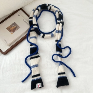 Detail of striped knitted skinny scarf in navy and blue with soft texture and tag