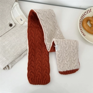 Detail van de tweekleurige gebreide wollen sjaal in oranje en beige met 100% wol label